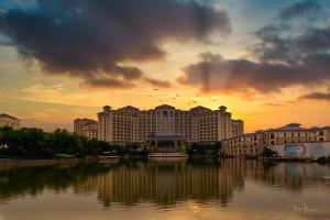 Grand Metropark Longxi Conference Center Beijing في بكين: اطلالة على مبنى كبير وامامه بحيرة