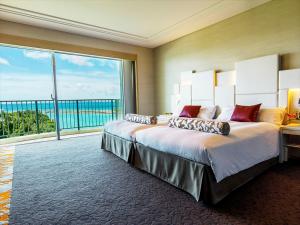 a bedroom with a large bed and a large window at Laguna Garden Hotel in Ginowan