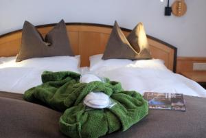 a green blanket on a bed with two pillows at Ferienhotel Gewürzmühle in Radstadt