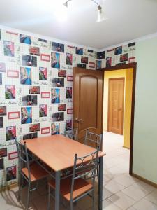 a table and chairs in a room with a wall of photos at Новострой Прокофьева in Sumy