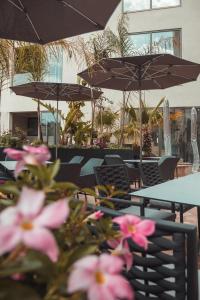 a table and chairs with pink flowers and umbrellas at The Village Boutique and SPA in Naxxar