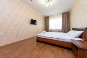 ein Schlafzimmer mit einem großen Bett und einem TV an der Wand in der Unterkunft Елизаветы Чавдар 34 in Kiew