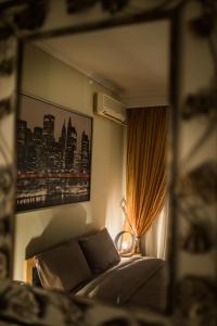 a bedroom with a bed and a window with a city at Comfort Studio in Thessaloniki