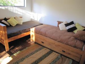 um quarto com duas camas com almofadas em Cabañas Ecobox Andino em Valle Las Trancas