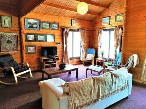 sala de estar con sofá, sillas y TV en The Cosy Mountain Cabin with Stunning Views near Troodos en Kato Amiandos