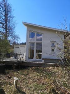 une maison avec une grande fenêtre sur une terrasse dans l'établissement Åsarna Hills Holiday Home Stillingsön, à Stillingsön