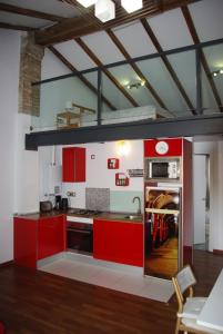 a kitchen with red cabinets and a stove top oven at Apartamento Centro Valencia in Valencia