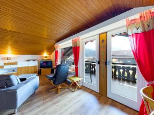 a living room with a couch and a balcony at Chalet Alpenglühen in Garmisch-Partenkirchen