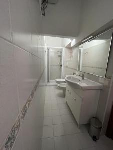 モノーポリにあるCala Fontanelleの白いバスルーム(洗面台、トイレ2つ付)