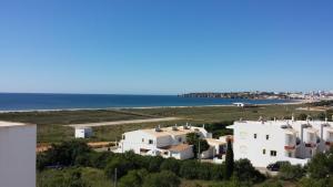 a group of white houses next to the ocean at Clube Meia Praia in Lagos