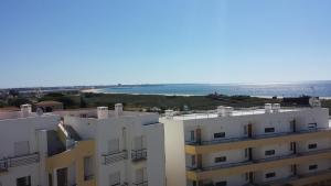 a view of a building with the ocean in the background at Clube Meia Praia in Lagos