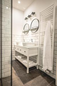een witte badkamer met een wastafel en een spiegel bij The Gallery in Bad Ischl