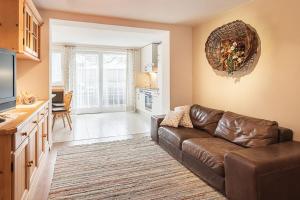 sala de estar con sofá marrón y cocina en Apartments Silva Alpenblick, en San Giovanni in Val Aurina