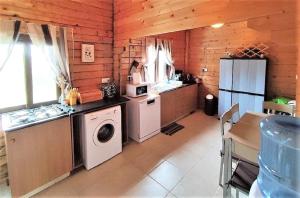 y cocina con fogones, lavadora y secadora. en The Cosy Mountain Cabin with Stunning Views near Troodos en Kato Amiandos