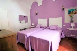 
a bed room with a pink bedspread and a blue bedspread at Casa Assuntina in Positano
