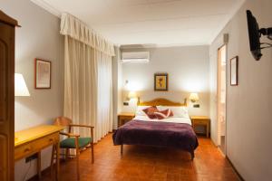 a hotel room with a bed and a desk at Hostal Restaurant Roma in Cubells
