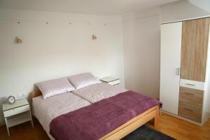 a bedroom with a bed with a purple blanket at House Minka in Ptuj