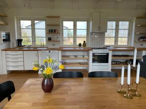 une cuisine avec une table et un vase de fleurs. dans l'établissement Strynø Living, à Rudkøbing
