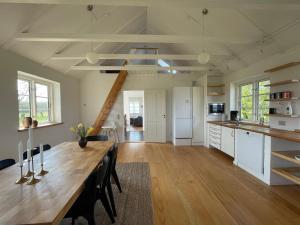 a large kitchen with a wooden table and a dining room at Strynø Living in Rudkøbing