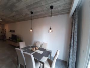 een eetkamer met een tafel, stoelen en verlichting bij QLiving Central New Apartments Gzira Sliema Promenade in Il-Gżira