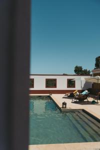 a swimming pool in front of a building at Herdade da Caniceira in Ervedal