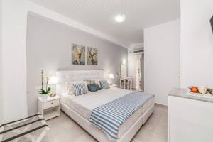 Dormitorio blanco con cama y barra en Roxani Hotel, en Amoudara Herakliou