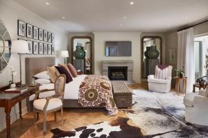 a bedroom with a bed and a desk and a fireplace at Hoeveld House in Johannesburg