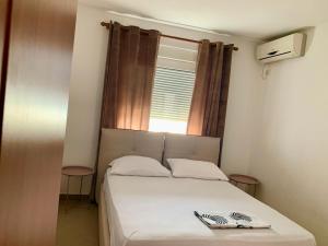 a small bedroom with a bed and a window at Guest House Ondine in Shëngjin