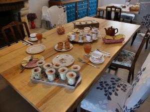 una mesa de madera con comida y bebidas. en Le Nid de Val'Ry, en Saint-Valery-sur-Somme