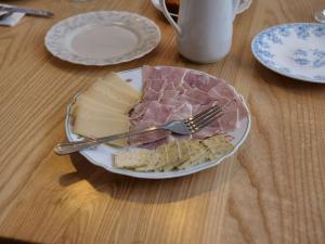 un plato de comida con queso y carne y un tenedor en Le Nid de Val'Ry en Saint-Valery-sur-Somme