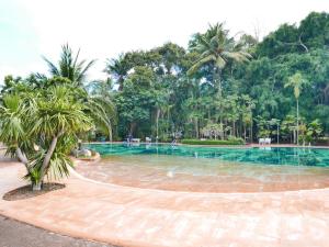 a swimming pool in a resort with palm trees at Oceanside Place Beach Resort in Ban Tha Fat