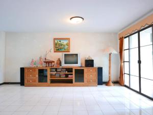 a living room with a television on a cabinet at Oceanside Place Beach Resort in Ban Tha Fat