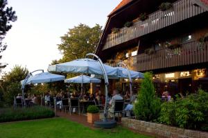 a restaurant with people sitting at tables under umbrellas at IDINGSHOF Hotel & Restaurant in Bramsche