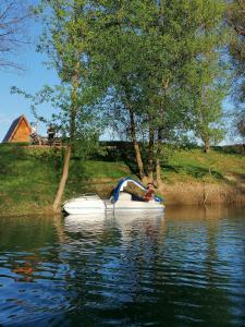 a person is sitting on a boat in the water at Studio apartman Zorkovac in Ozalj
