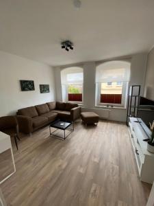 a living room with a couch and a table at FEDDERSEN LIVING Moderne Ferienwohnungen - Gemütlich - Netflix - Voll ausgestattet - Waschmaschine - zentral gelegen in Brunsbüttel