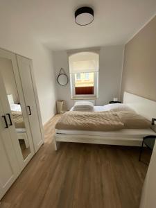 Un dormitorio con una cama grande y una ventana en FEDDERSEN LIVING Moderne Ferienwohnungen - Gemütlich - Netflix - Voll ausgestattet - Waschmaschine - zentral gelegen, en Brunsbüttel