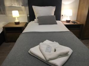 łóżko z białymi ręcznikami i laptopem w obiekcie Aranykorona Apartmanház w Miszkolcu +37 zdjęć