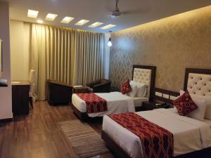 a hotel room with two beds and avisor at Hotel JSR Continental in Dehradun