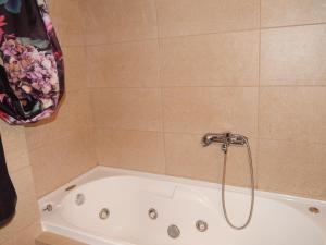 a bath tub with a shower in a bathroom at Zira Holiday House in Makrýgialos +39 photos