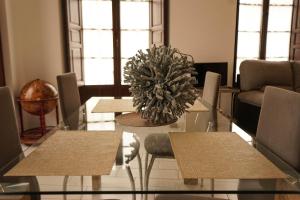 un comedor con una mesa con sillas y una planta en Casco Historico Apt. Doña Concha en Ronda