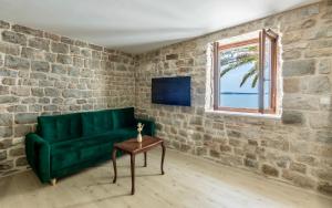 a green couch and a table in a room with a window at D & D Luxury Apartment in Kaštela