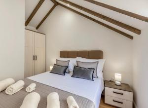 a bedroom with a large white bed with two pillows at D & D Luxury Apartment in Kaštela