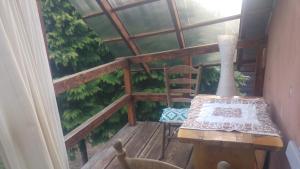 eine Veranda mit einem Tisch und einem Stuhl auf dem Balkon in der Unterkunft Agrochillout Gospodarstwo agroturystyczne in Zagnańsk Zachełmie + 10 Fotos