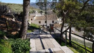 a staircase leading to a white house with trees at Casa Rural Fuente Zagrilla in Zagrilla