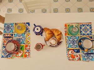 een tafel met een bord croissants en een kopje koffie bij Casa Mandara B&B in Positano