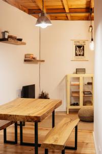 ein Esszimmer mit einem Holztisch und Bänken in der Unterkunft Casa Gaveto in Sabugal
