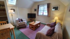 a living room with two couches and a tv at Willows Cottage in Pitlochry