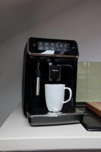 a coffee maker with a cup on a counter at Ferienwohnung Groß Taubertal in Königheim