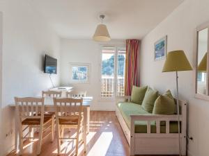 a living room and dining room with a couch and a table at Vacancéole - Résidence L'Ile d'Or in La Londe-les-Maures