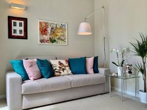 a living room with a couch with colorful pillows at Villa Luminosa in Torre del Lago Puccini